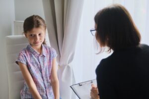 Lernentwicklungsgespräch in der Grundschule - Frau spricht mit Mädchen