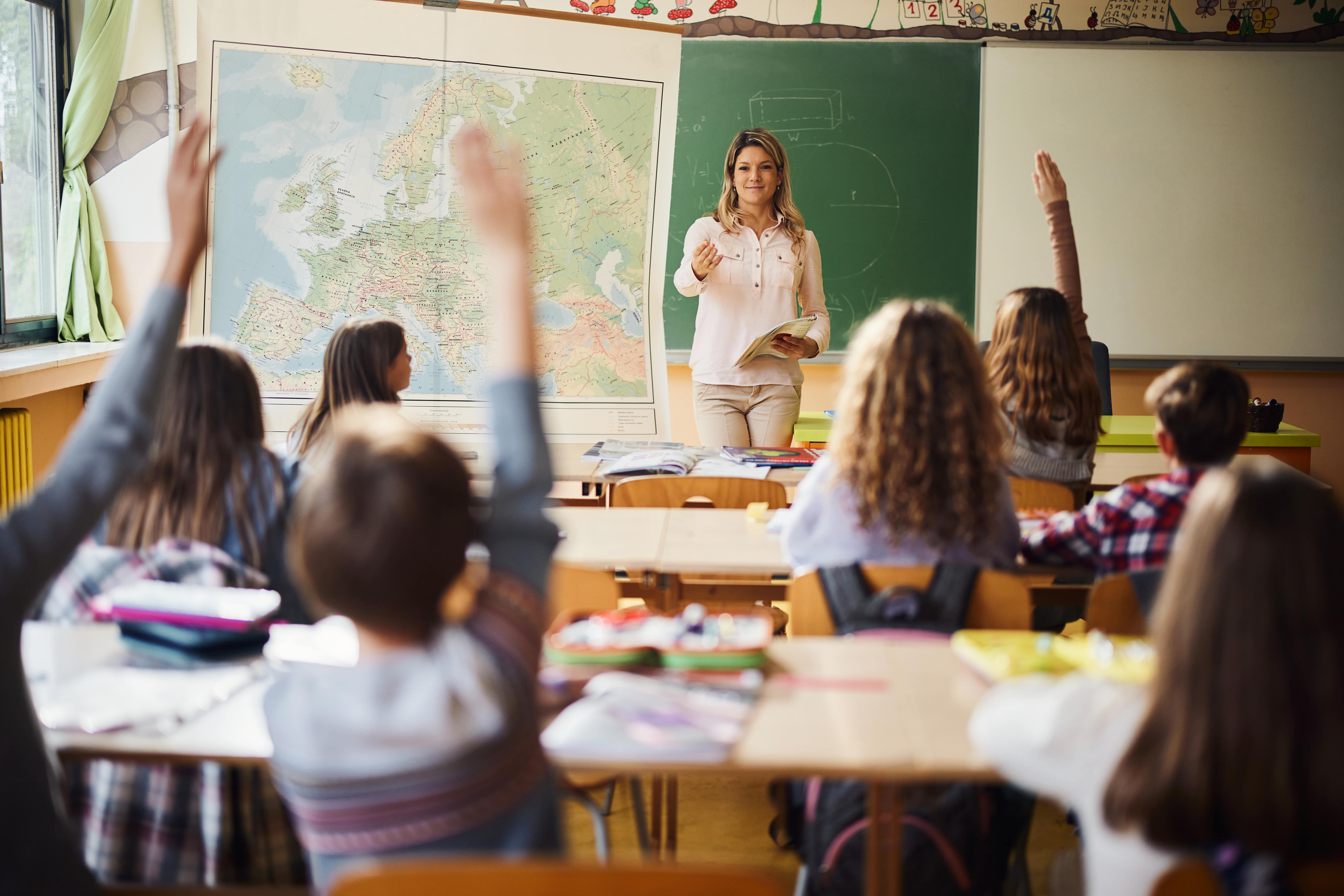 Schulnoten: Kinder melden sich in der Klasse